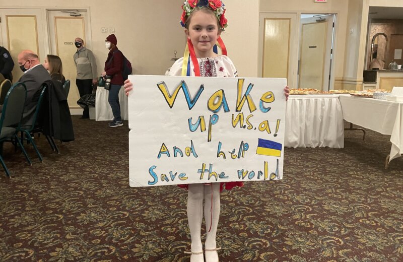JOVEM UCRANIANA QUE VIVE EM DETROIT (EUA), EXPÕE CARTAZ  QUE PEDE SOCORRO  DO MUNDO À UCRÂNIA